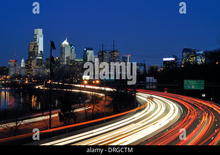 Skyline von Philadelphia in der Abenddämmerung von 34th St. in der Nähe von Philadelphia Zoo mit dem Schuylkill Expressway im Vordergrund. Stockfoto