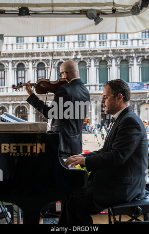 Musiker spielen vor einem Publikum in einem Restaurant in Saint Markusplatz, Venedig Stockfoto