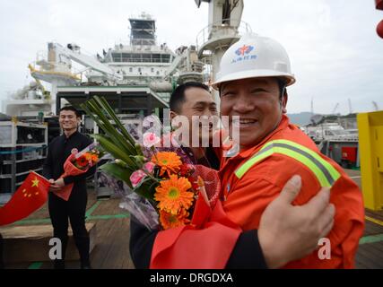 (140125)--SHENZHEN, 25. Januar 2014 (Xinhua)--Taucher Hu Jian (Front L) wird von einem Mitarbeiter begrüßt, nach, die sich sicher aus einer lebendigen Kammer auf einem Schiff an einem Dock in Shenzhen, Guangdong Provinz Süd-China, 25. Januar 2014 verankert. Eine Taucherglocke nahm die Taucher zu erreichen eine Tiefe von 313,5 m unter dem Südchinesischen Meer am 12. Januar. Dann kehrte die Taucher aus tiefem Wasser in der lebenden Kammer auf ihr Schiff. Nach einem Aufenthalt in der Kammer für 380 Stunden das Inertgas in ihrer Gewebeflüssigkeit auf Normaldruck zurückkehren zu lassen, kam die sechs Taucher auf Jan. 25 mit gesunden Körper Bedingungen. Dies Stockfoto