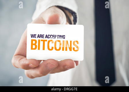 Geschäftsmann, die Karte mit dem Titel wir sind akzeptieren BITCOINS halten. Selectve Fokus auf Karte und Fingern. Stockfoto