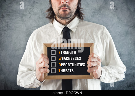 Businessman holding blackboard with SWOT ANALYSIS title. Business analysing concept. Stockfoto