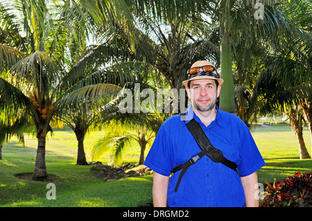 Weißer Tourist Mann posiert vor tropischen Palmen Stockfoto