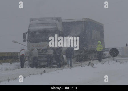 Bukarest, Rumänien. 26. Januar 2014. Menschen versuchen, einen LKW auf einer Schnee-beschichtete Straße am Stadtrand von Bukarest, Hauptstadt Rumäniens, am 26. Januar 2014 zu verschieben. Laut der nationalen Wetter Verwaltung von Rumänien sind Buzau und anderen 2 Landkreisen unter Code Red-Warnungen für Schneestürme. Drei Personen wurden tot wegen Schnee und Blizzard erklärt. Bildnachweis: Gabriel Petrescu/Xinhua/Alamy Live-Nachrichten Stockfoto