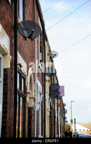 TV Sender Satellitenschüsseln auf Seiten der Häuser auf terrassenförmig angelegten Straße in Burslem Stoke-on-Trent Staffordshire Stockfoto