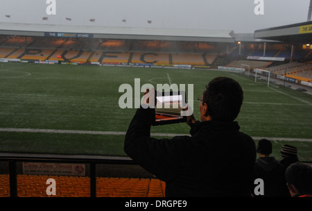 Stürmisches Wetter auf dem Port Vale Fußballplatz in Burslem Stoke in Trent Staffordshire, wo Reporter Fotos auf dem iPad-Computer machen Stockfoto