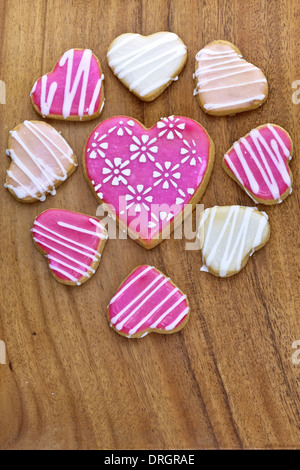 Geeiste herzförmige Cookies auf Holzbrett. Stockfoto
