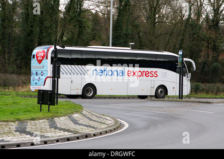 National Express Coach verlassen eines Kreisverkehrs in Coulsdon, Surrey, England. Stockfoto
