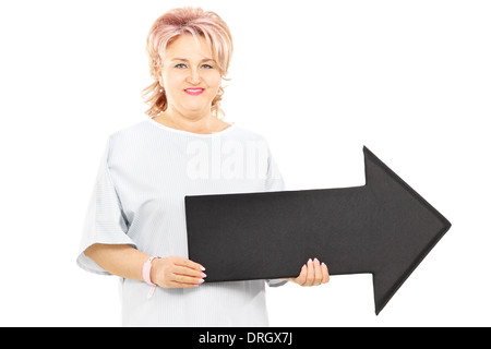 Patientin in Krankenhemd großen schwarzen Pfeil rechts halten Stockfoto