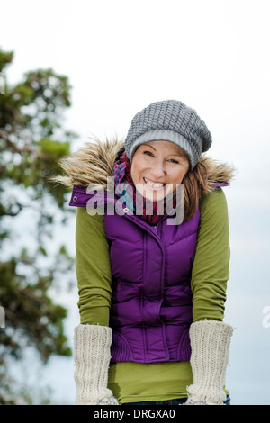 Fröhliche Frau in Winterkleidung in der Natur - Frau im Winter kleiden in der Natur Stockfoto