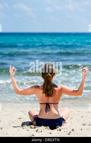 Frau Im Bikini Macht Joga bin Strand, Spanien, Ibiza - Frau tut Yoga am Strand, Ibiza, Spanien Stockfoto