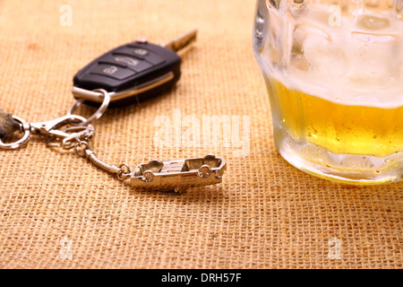 Fahrzeugschlüssel mit Unfall und Bier-Becher, Nahaufnahme Stockfoto