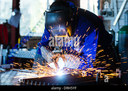 Verklebung von Metall mit Gerät in Werkstatt, viele Funken abzuwarten, He trägt Googles Schweißen Schweißen Schweißer Stockfoto