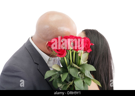 Zwei junge Termine küssen hinter einen Strauß roter Rosen Stockfoto