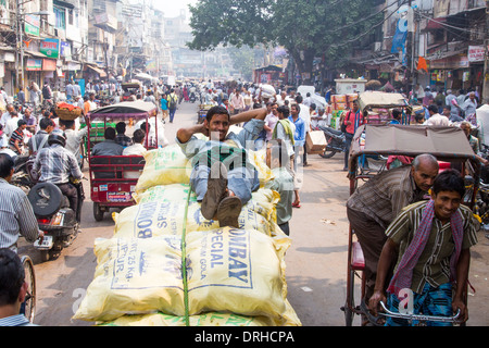 Porter ruht auf Säcke von Gewürzen in der Gewürzmarkt, Old Delhi Indien Stockfoto