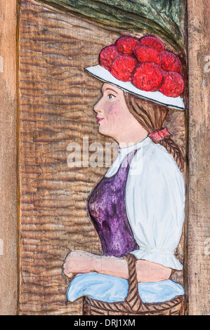 Holzschnitzerei zeigt eine junge unverheiratete Frau aus der Schwarzwald-Region trägt die roten Bollenhut-Kopfbedeckungen Stockfoto