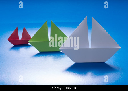 Gruppe von Papier Schiffe segeln auf blauem Papier Meer. Origami Boot. Papier-Meer Stockfoto