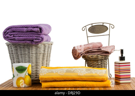 Weidenkorb voller farbige Handtücher auf einem Holztisch im Badezimmer set Stockfoto