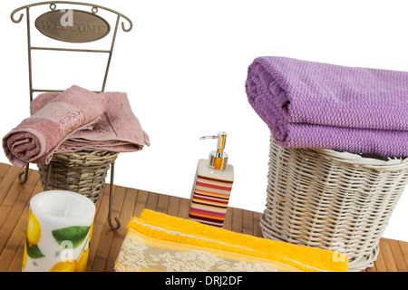 Weidenkorb voller farbige Handtücher auf einem Holztisch im Badezimmer set Stockfoto