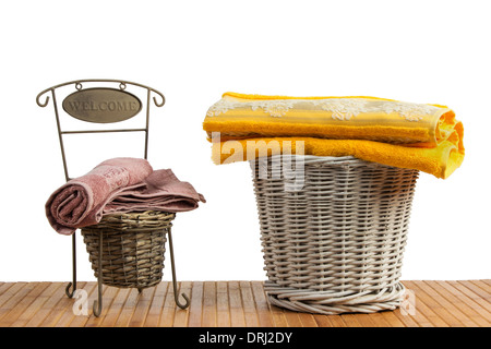 Weidenkörbe voll von farbigen Handtücher auf einem Holztisch, auf weißem Hintergrund Stockfoto