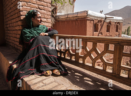 Eine Frau mit einem grünen Hijab auf Balustrade in Abyāneh, Unabhängigkeitsbewegung-e Esfahan, Iran Stockfoto