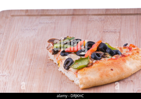 Vegetarische Pizza Stück auf ein Schneidebrett mit Platz auf Links, Richtfest gehören Oliven Tomaten, Paprika und Käse Stockfoto