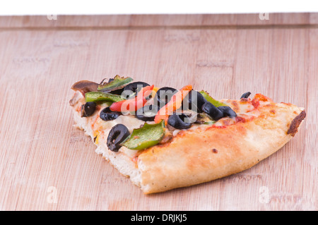 Vegetarische Pizza Stück auf einem Schneidebrett Belag gehören Oliven Tomaten, Paprika und Käse Stockfoto