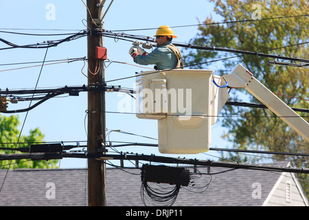 Energie Ingenieur im Aufzug bucket arbeiten an elektrischen Leitungen und Anpassung Spannung, Braintree, Massachusetts, USA Stockfoto