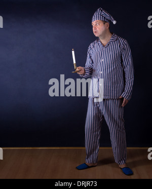 Angst vor Menschen mit Kerze im Pyjama Stockfoto