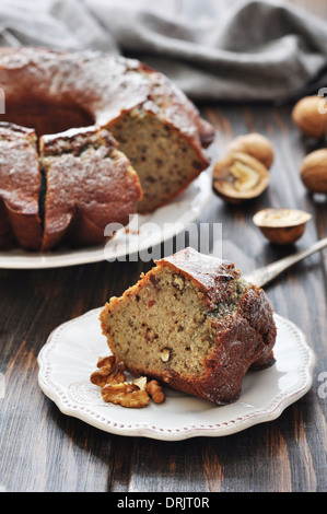 Stück Kuchen mit Rosinen und Walnüssen auf hölzernen Hintergrund Stockfoto