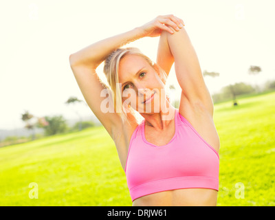 Attraktive Fit junge Frau stretching vor Übung Training, Sonnenaufgang am frühen Morgen Hintergrundbeleuchtung. Gesunde Lebensweise Fitnesskonzept. Stockfoto