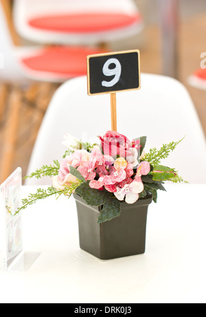 Künstlich im schwarzen Kunststoff Vase am Tisch. Stockfoto