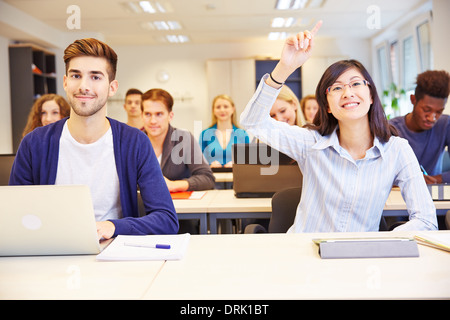 Asiatische Studentin hob ihre Hand in eine Universität Klasse Stockfoto