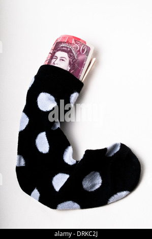Fünfzig Pfund-Banknoten gefüllt in eine Socke Stockfoto