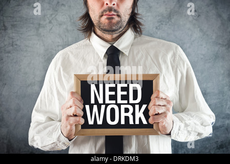 Businessman needs a job. Manager holding blackboard with title NEED WORK Stockfoto