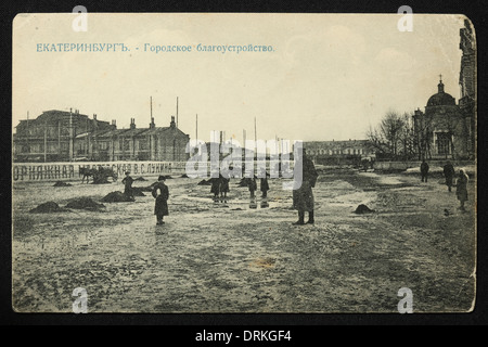 Schlamm und Pfützen auf dem Domplatz, auch als Marktplatz in Jekaterinburg, Russisches Reich bekannt. Schwarz-Weiß-Vintage-Fotografie des russischen Fotografen Nikolai Vwedensky datiert vom Anfang des 20. Jahrhunderts, ausgestellt in der russischen Vintage-Postkarte von M.S. Semkov, Jekaterinburg. Foto von Nikolai Wwedenski. Text auf Russisch: Jekaterinburg. Städtische Verschönerung. Mit freundlicher Genehmigung der Azoor Postcard Collection. Stockfoto