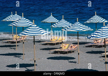 Muster der Sonnenschirme Sonnenschirme & Sonnenliegen auf einsamen Strand & Mittelmeer Rhodos Griechenland Stockfoto