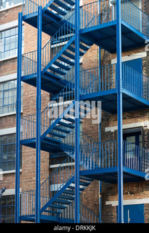 Blaue externe Feuerleiter Treppe auf zeitgenössische Arbeitsbereich im ehemaligen Lagerhaus viktorianische Backstein am Highgate Studios London UK Stockfoto