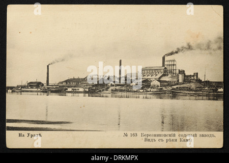 Natriumfabrik und der Kama-Fluss in Berezniki im Ural, Russisches Reich. Schwarz-Weiß-Vintage-Fotografie des russischen Fotografen Veniamin Metenkov vom Anfang des 20. Jahrhunderts, ausgestellt in der russischen Vintage-Postkarte, die von Veniamin Metenkov selbst in Jekaterinburg, Russland, herausgegeben wurde. Text auf Russisch: Im Ural. Berezniki Natriumfabrik. Blick vom Kama River. Mit freundlicher Genehmigung der Azoor Postcard Collection. Stockfoto