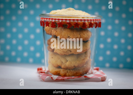 Glas voll von Chocolate Chip Cookies vor blauem Hintergrund mit weißen Punkten Stockfoto