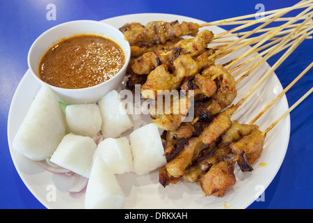 Schweinefleisch-Satay mit Penut Sauce Reis Kuchen Ketupat Zwiebeln und Gurken Closeup Stockfoto