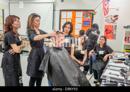 Als asiatisch-amerikanische sehen Friseure, ein Mann bekommt einen neuen Haarschnitt von Arbeiten Schränke, eine Organisation, die hilft, die Arbeitslose Kleid und der Bräutigam für erfolgreiches Geschäft Vorstellungsgespräche in Südkalifornien. Der Haarschnitt ist Teil einer "Beschäftigung Erfolg Workshop. Stockfoto