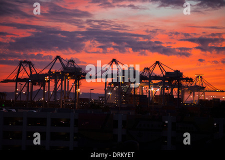 Sonnenuntergang Silhouetten Container Fracht Ladekrane im Hafen von Long Beach, CA. Stockfoto