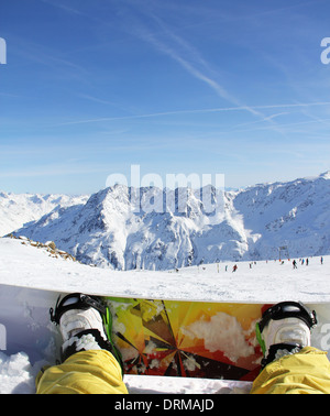 Snowboarder sitzend auf Schnee Stockfoto