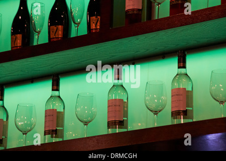 Flaschen Jacobs Creek Sauvignon Blanc Weißwein und Weingläser in Regalen mit grüner Beleuchtung Stockfoto