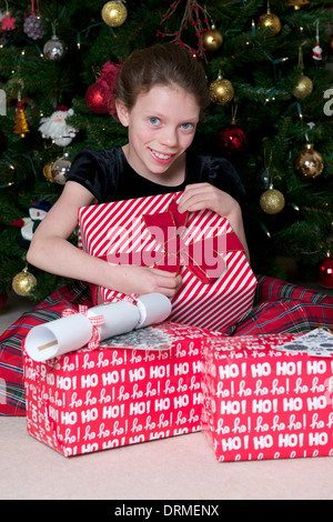 Mädchen, die Weihnachtsgeschenke zu öffnen Stockfoto