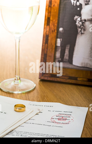 Scheidung-Dokumente auf einem Tisch mit Ehering und Hochzeitsfoto. Stockfoto