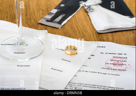 Scheidung-Dokumente auf einem Tisch mit Ehering und Hochzeitsfoto. Stockfoto