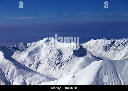 Blick auf Tiefschneehänge und multicolor blauer Himmel bei schönen sonnigen Abend. Kaukasus, Georgien, Skigebiet Gudauri. Stockfoto