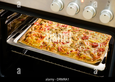 Hausgemachte Salami Pizza im Ofen Stockfoto