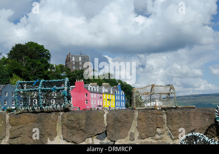 Einige der bunten Häuser von Tobermory umrahmt von Crab Pots vom Hafen entfernt. Stockfoto